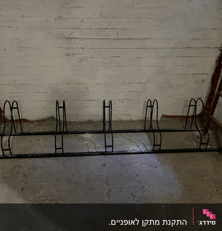 מתקן מתכת לאחסון אופניים על רצפה אפורה